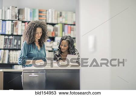Businesswomen working together in office View Large Photo Image Stock Image - Businesswomen working together in office. Fotosearch