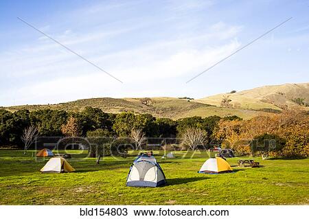 Stock Image - Camping tents in remote grassy field. Fotosearch