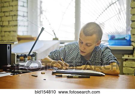 Stock Image - Caucasian artist drawing at studio desk. Fotosearch
