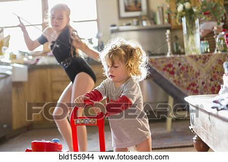 Caucasian baby boy and older sister playing in kitchen View Large Photo Image Picture - Caucasian baby boy and older sister playing in kitchen. Fotosearch
