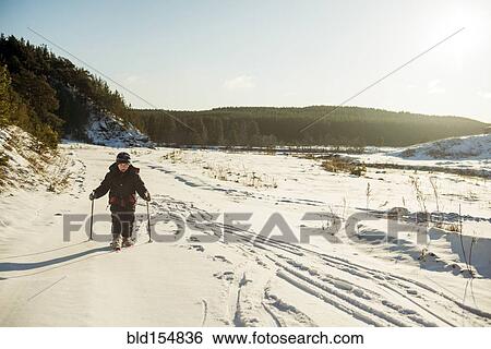 Stock Photograph - Caucasian boy cross-country skiing in snowy field. Fotosearch