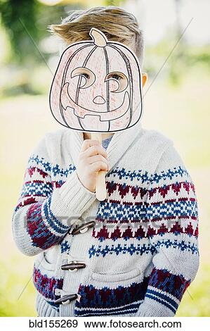 Caucasian boy holding jack-o-lantern mask View Large Photo Image Stock Photo - Caucasian boy holding jack-o-lantern mask. Fotosearch