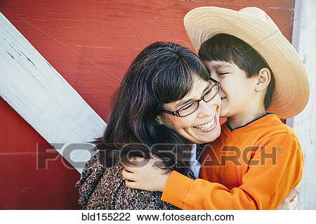 Stock Image - Caucasian boy kissing cheek of mother. Fotosearch