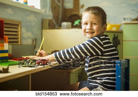 Caucasian boy painting at desk in playroom View Large Photo Image Stock Image - Caucasian boy painting at desk in playroom. Fotosearch
