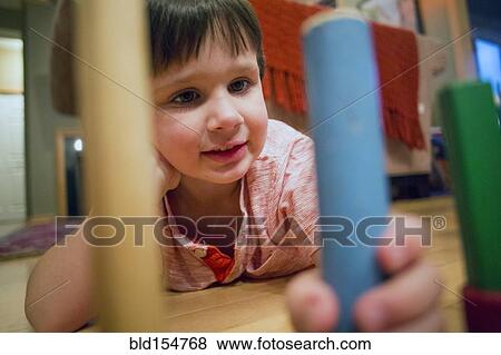 Stock Photo - Caucasian boy playing with blocks on floor. Fotosearch