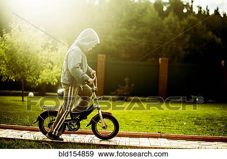 Caucasian boy riding bicycle in backyard View Large Photo Image Stock Photo - Caucasian boy riding bicycle in backyard. Fotosearch