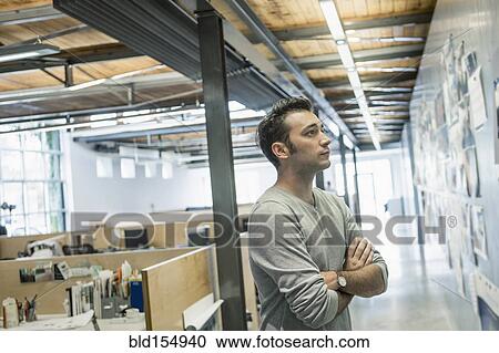 Caucasian businessman examining photographs on wall in office View Large Photo Image Stock Image - Caucasian businessman examining photographs on wall in office. Fotosearch