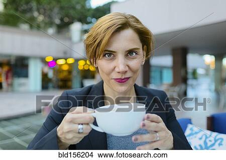 Caucasian businesswoman drinking coffee at sidewalk cafe View Large Photo Image Picture - Caucasian businesswoman drinking coffee at sidewalk cafe. Fotosearch
