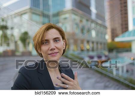Stock Photo - Caucasian businesswoman sitting in city park. Fotosearch