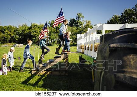 Stock Photo - Caucasian children climbing stairs to hay ride on farm. Fotosearch