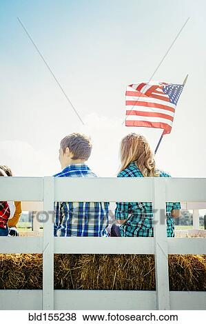 Caucasian children waving American flag on hay ride View Large Photo Image Stock Photo - Caucasian children waving American flag on hay ride. Fotosearch