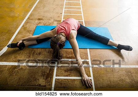 Stock Photography - Caucasian dancer stretching in gym. Fotosearch
