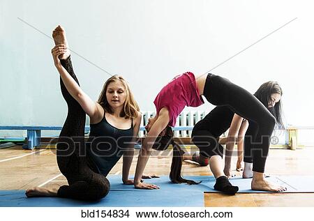 Picture - Caucasian dancers stretching in gym. Fotosearch