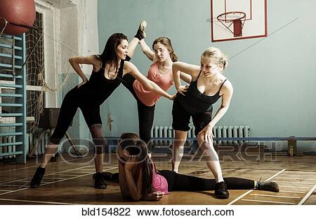 Stock Image - Caucasian dancers stretching in gym. Fotosearch