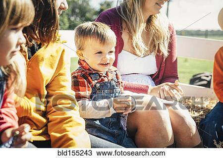 Caucasian family sitting on hay ride View Large Photo Image Stock Image - Caucasian family sitting on hay ride. Fotosearch