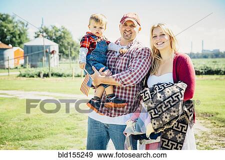 Caucasian family smiling on farm View Large Photo Image Stock Photo - Caucasian family smiling on farm. Fotosearch