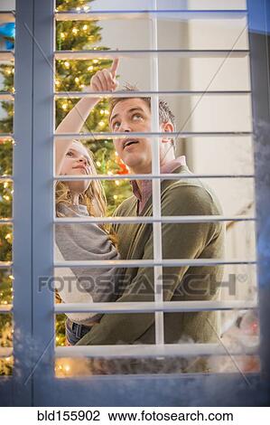 Stock Image - Caucasian father and daughter looking for Santa at Christmas. Fotosearch