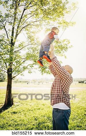 Stock Photography - Caucasian father and son playing on farm. Fotosearch