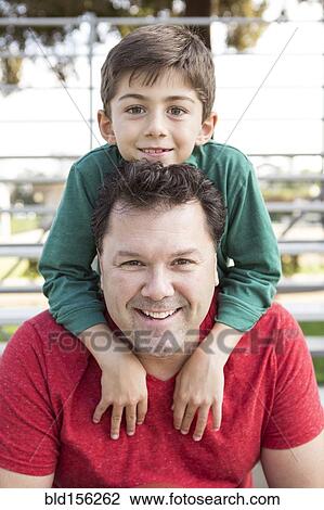 Stock Image - Caucasian father and son playing on bleachers. Fotosearch