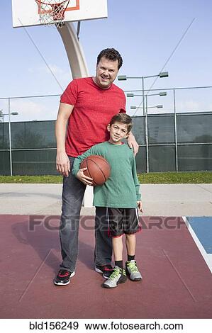 Stock Photo - Caucasian father and son playing on basketball court. Fotosearch