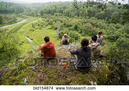 Picture - Caucasian friends admiring scenic view from rural hilltop. Fotosearch