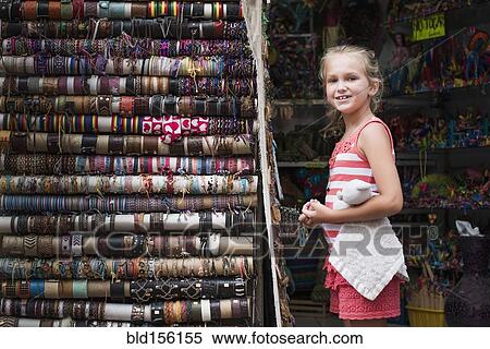 Caucasian girl admiring woven bracelets for sale in market View Large Photo Image Stock Photography - Caucasian girl admiring woven bracelets for sale in market. Fotosearch