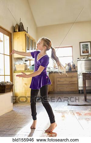 Stock Photograph - Caucasian girl dancing in kitchen. Fotosearch
