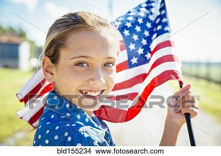 Picture - Caucasian girl waving American flag on farm. Fotosearch