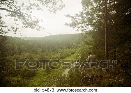 Caucasian man admiring scenic view from rural hilltop View Large Photo Image Stock Image - Caucasian man admiring scenic view from rural hilltop. Fotosearch
