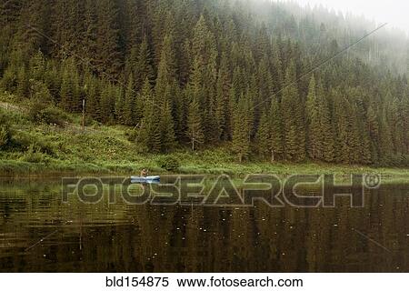 Caucasian man rowing canoe in remote lake View Large Photo Image Stock Photography - Caucasian man rowing canoe in remote lake. Fotosearch