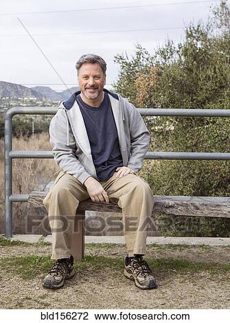 Caucasian man sitting on bench in park View Large Photo Image Stock Image - Caucasian man sitting on bench in park. Fotosearch