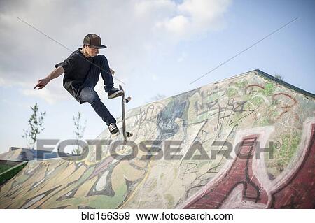 Stock Photo - Caucasian man skating at skate park. Fotosearch