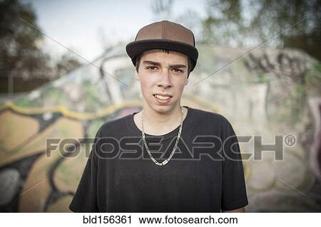 Stock Image - Caucasian man standing at skate park. Fotosearch