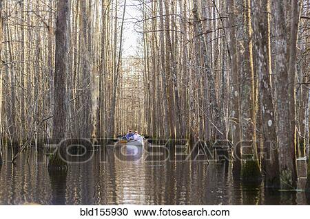 Stock Image - Caucasian men rowing canoes on river. Fotosearch