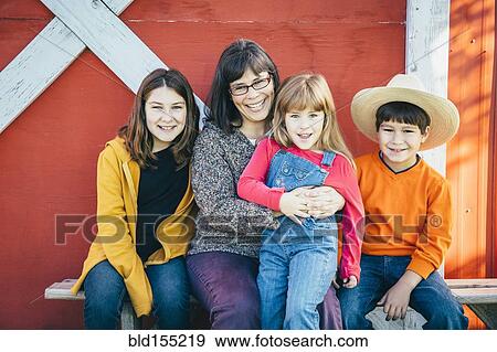 Stock Photo - Caucasian mother and children smiling outside barn. Fotosearch