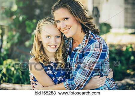 Caucasian mother and daughter hugging outdoors View Large Photo Image Stock Photo - Caucasian mother and daughter hugging outdoors. Fotosearch