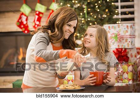 Caucasian mother and daughter leaving cookies and milk for Santa at Christmas View Large Photo Image Picture - Caucasian mother and daughter leaving cookies and milk for Santa at Christmas. Fotosearch