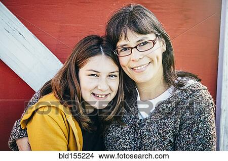 Caucasian mother and daughter smiling outside barn View Large Photo Image Picture - Caucasian mother and daughter smiling outside barn. Fotosearch