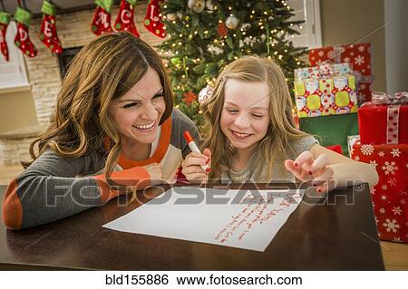 Caucasian mother and daughter writing to Santa at Christmas View Large Photo Image Stock Photograph - Caucasian mother and daughter writing to Santa at Christmas. Fotosearch