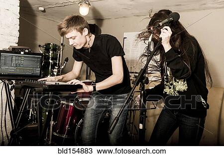 Stock Image - Caucasian musicians playing in rock band. Fotosearch