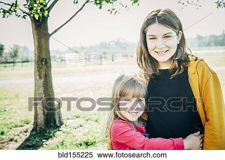 Stock Photography - Caucasian sisters smiling on farm. Fotosearch