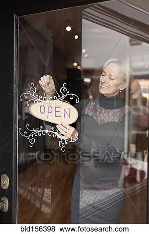 Caucasian small business owner hanging open sign on front door View Large Photo Image Stock Photo - Caucasian small business owner hanging open sign on front door. Fotosearch