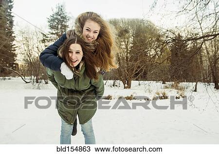 Caucasian woman carrying friend piggyback in snowy field View Large Photo Image Stock Image - Caucasian woman carrying friend piggyback in snowy field. Fotosearch