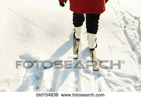 Stock Photo - Caucasian woman cross-country skiing in snowy field. Fotosearch