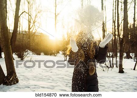Stock Image - Caucasian woman playing in snowy field. Fotosearch