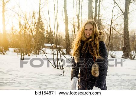 Stock Image - Caucasian woman playing in snowy field. Fotosearch