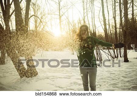 Stock Photo - Caucasian woman playing in snowy field. Fotosearch