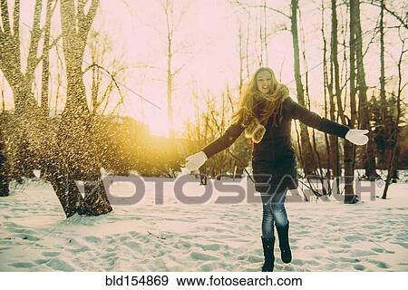 Caucasian woman playing in snowy field View Large Photo Image Stock Photo - Caucasian woman playing in snowy field. Fotosearch