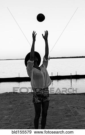 Stock Photo - Caucasian woman playing with coconut on beach. Fotosearch