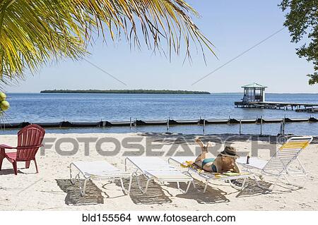 Picture - Caucasian woman relaxing on tropical beach. Fotosearch